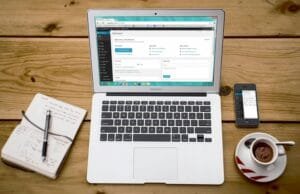 this image showing a coding interface in laptop on a workspace and Zumezu IT compony providing web development in delhi,